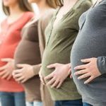 Vier zwangere vrouwen met handen op de buik