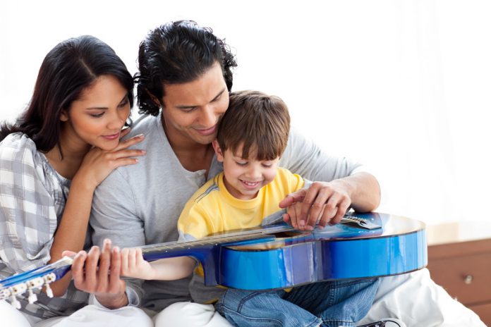 vader en moeder leren kind gitaar spelen
