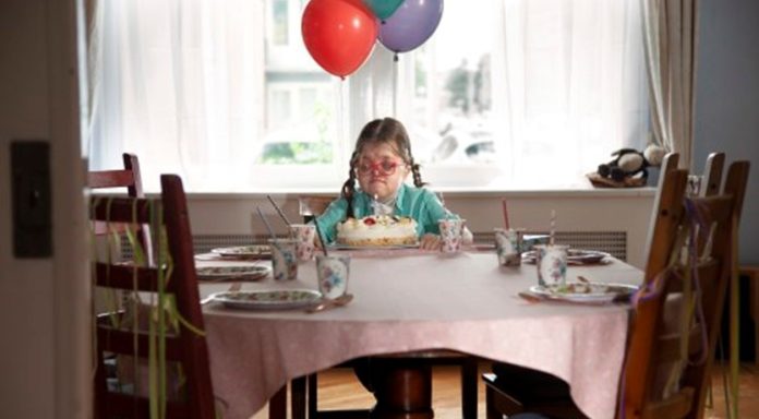 gehandicapt meisje zit alleen aan tafel